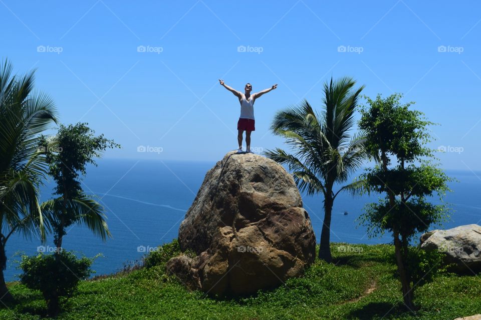 Enjoying sun and landscape . Enjoying the amazing coast view and the burning sun on a rock on the monkey mountains in da nang Vietnam. 
