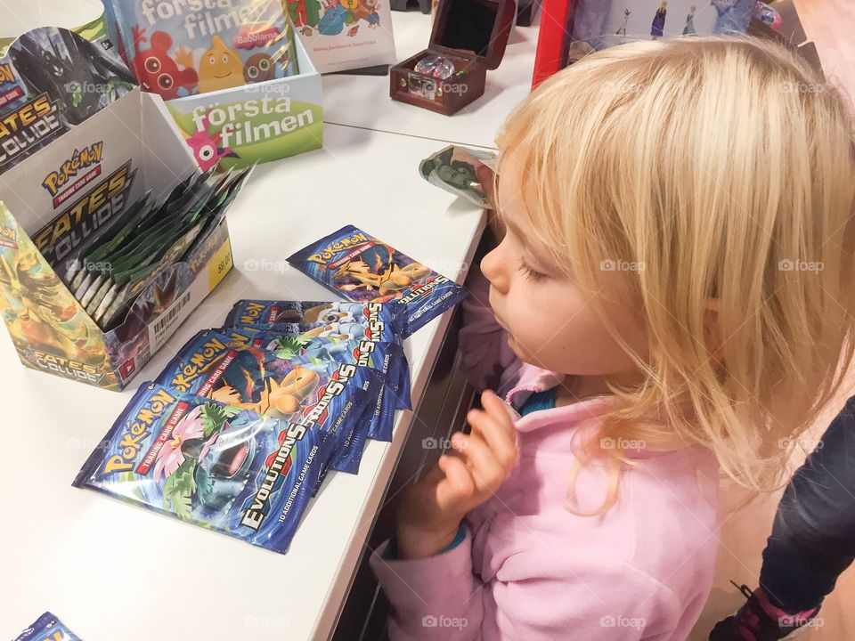 Young girl is bying Pokemon cards in a toystore in Malmö Sweden.