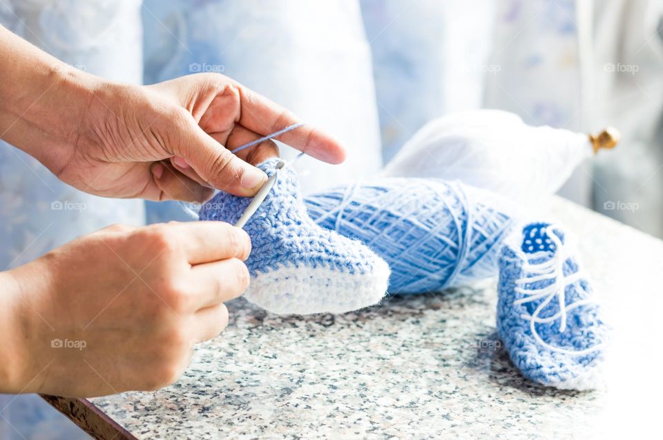 Woolen baby shoes knitting.