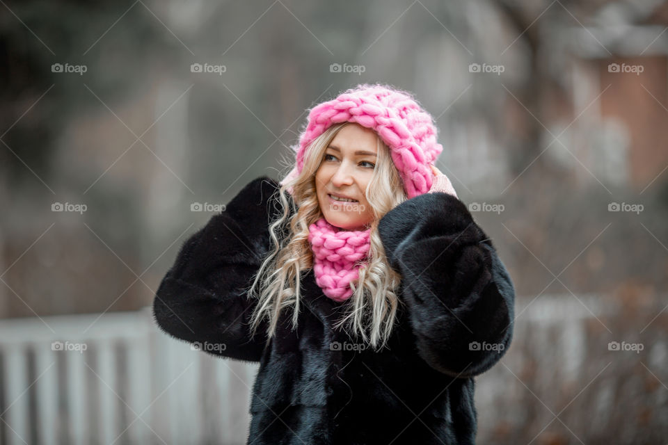 Outdoor Portrait of blonde woman in pink crochet accessories 