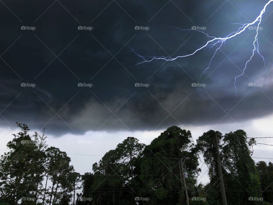 Black clouds and lightning indicating a supersized rainstorm impending.