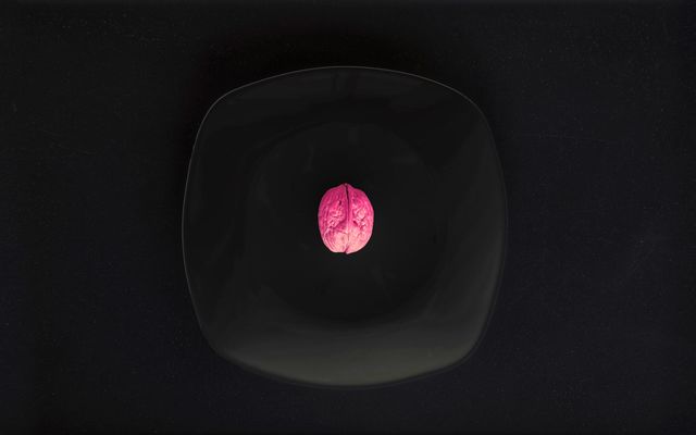 Purple walnut on a black in a dark room, viewed from top 