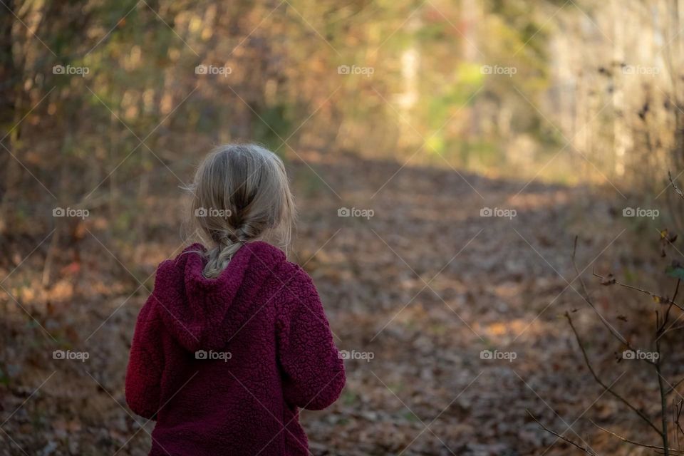 Little girl strolling in the woods. 
