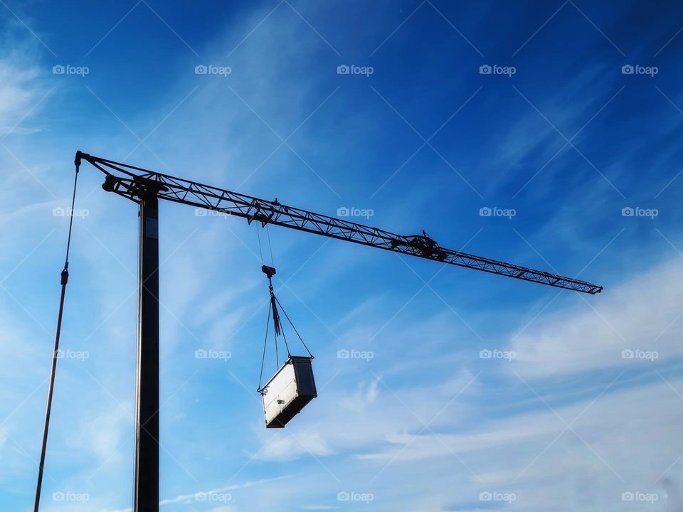 moving crane with hooked construction material