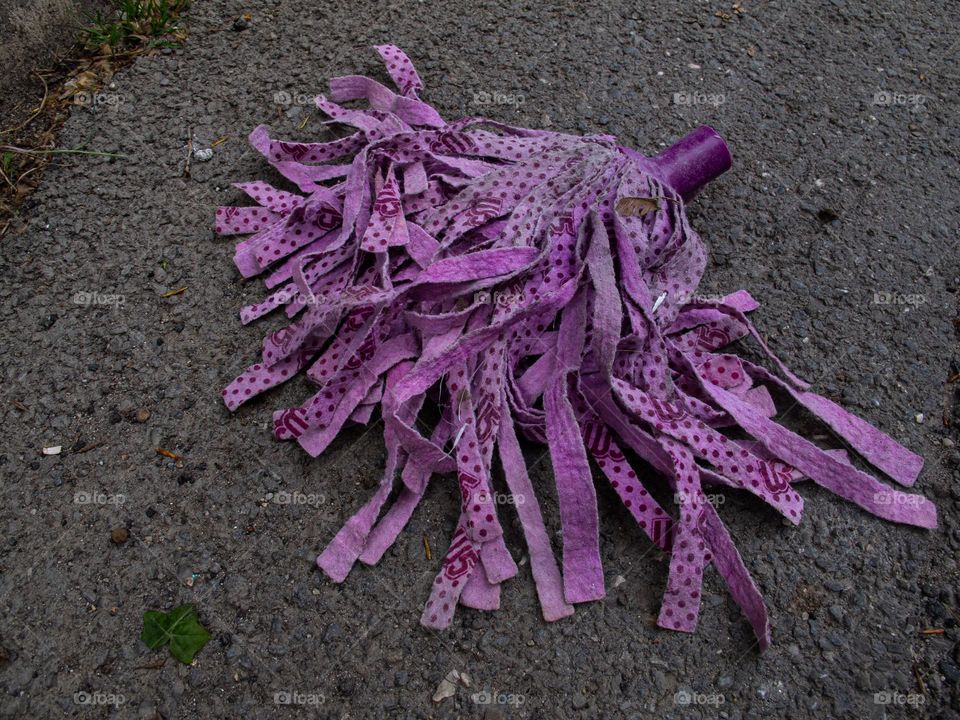 Used purple mop on sidewalk 