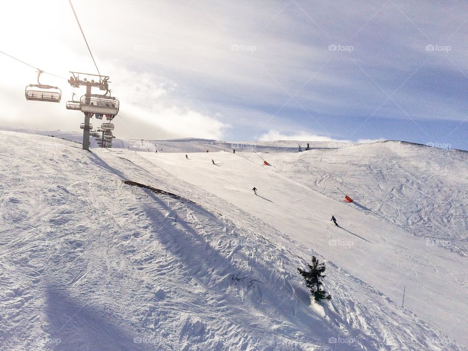 Skiing and ski lift in snow mountains