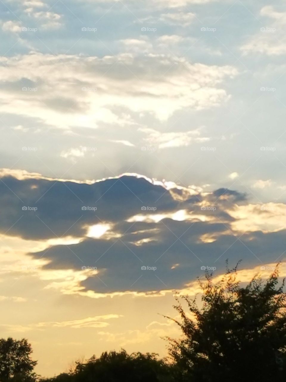 sun setting behind the clouds