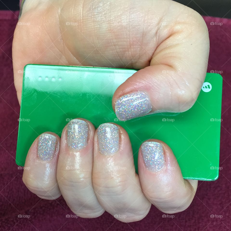 Silver sparkle manicure with bright green background