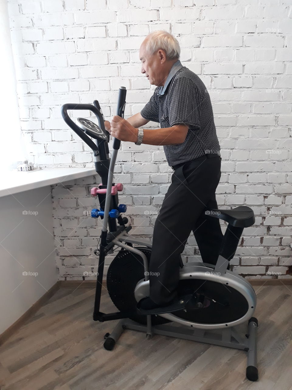пожилой мужчина занимается спортом на тренажере