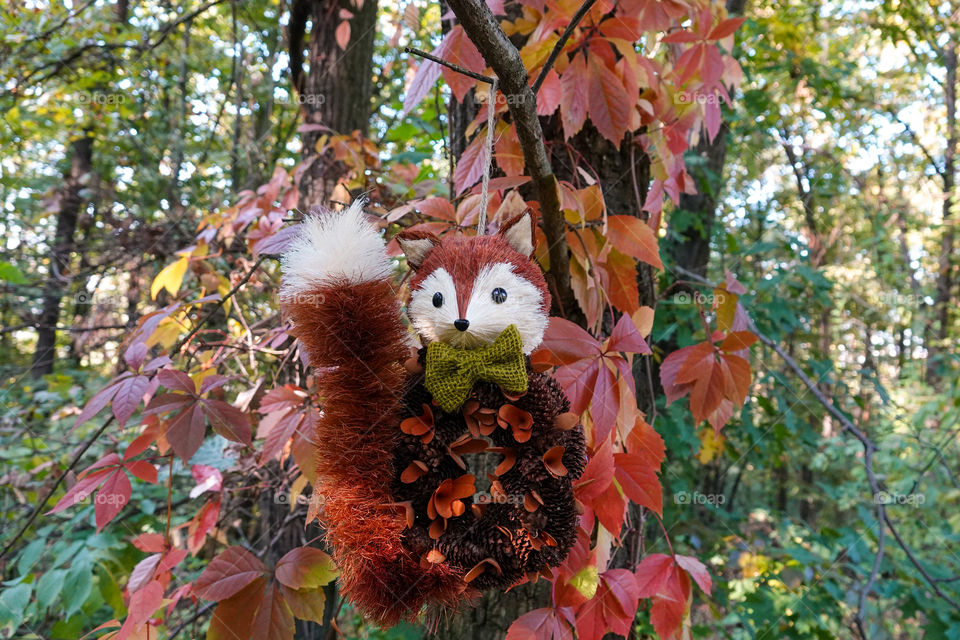 Cute fox decoration in autumn forest.