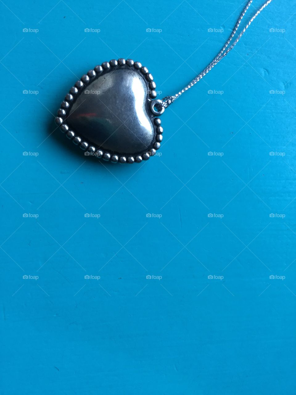 Blue background with silver heart. 
