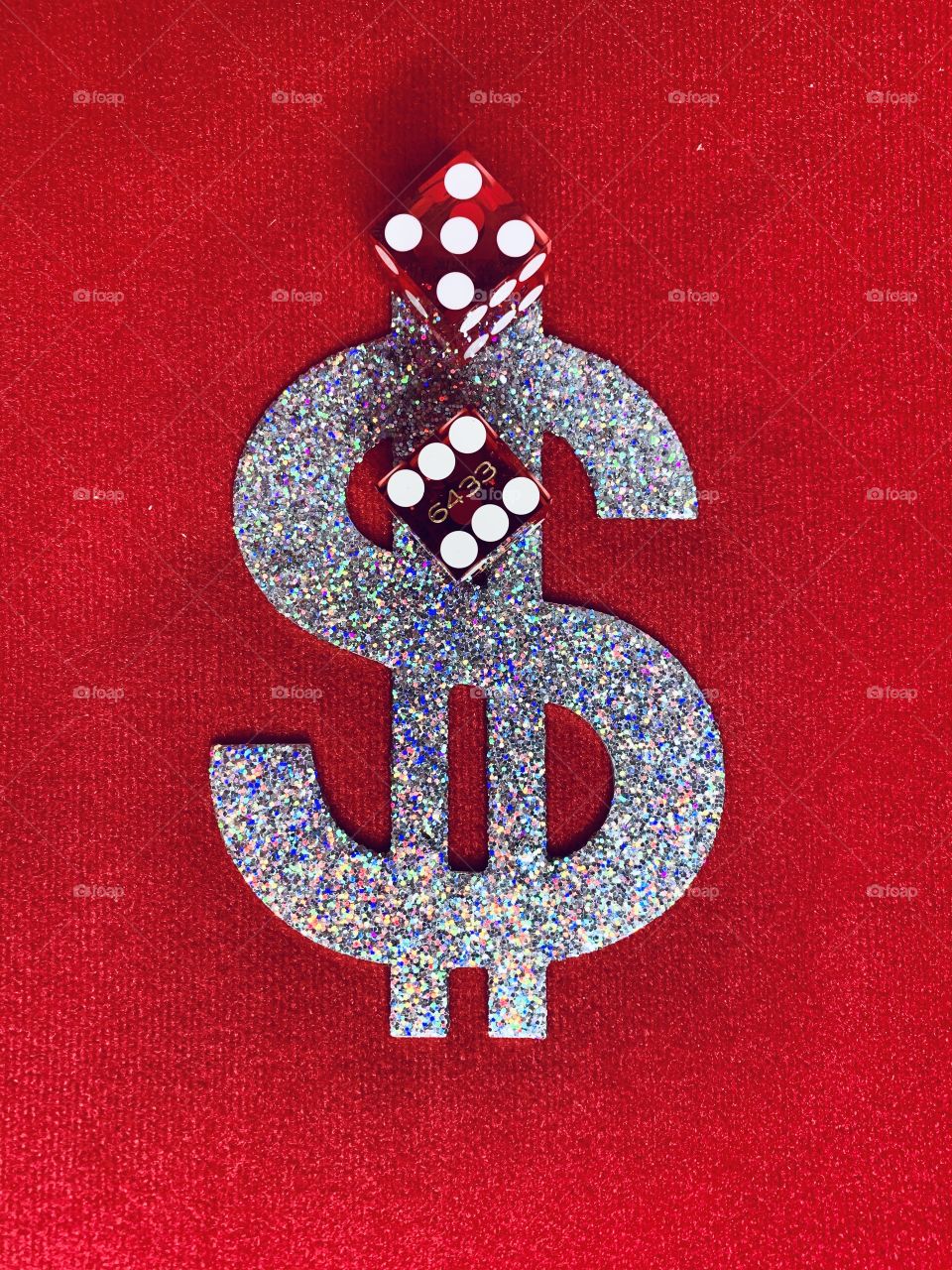 D - A pair of red dice on a dollar sign with red background. Dice are small, throwable objects with marked sides that can rest in multiple positions, part of tabletop games, including dice games, board games