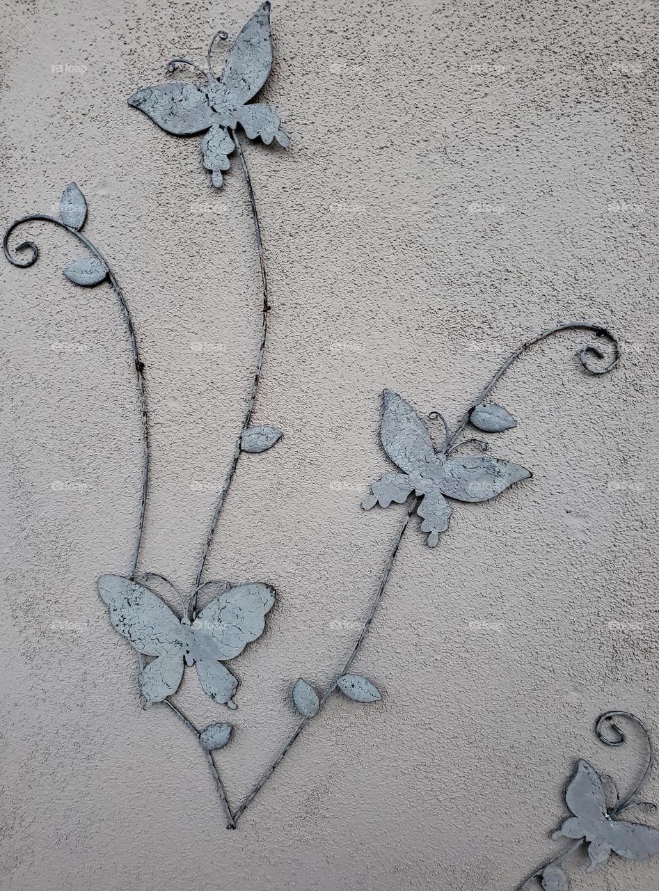 Metal Butterflies on a Stucco Wall