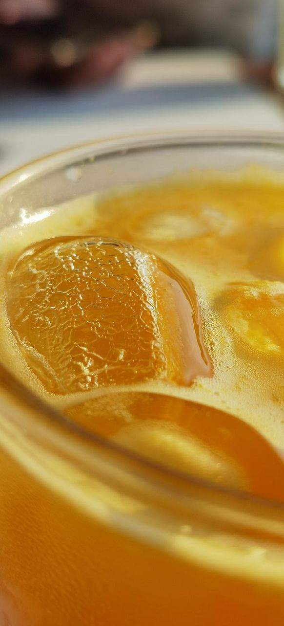 Close up of ice cube in an orange juice glass