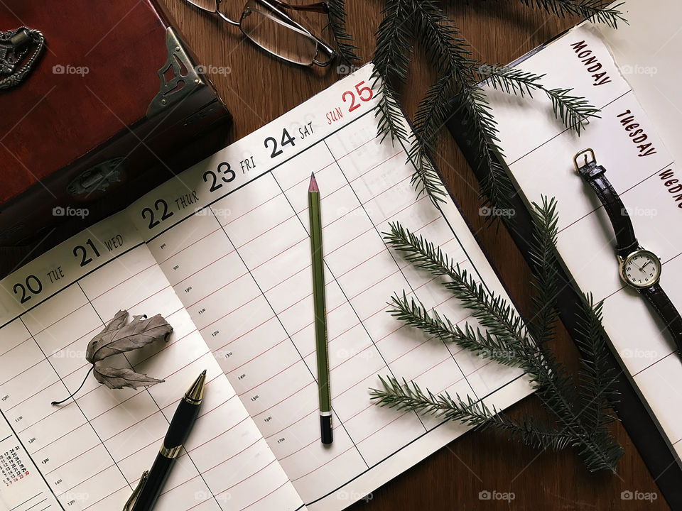 Calendar, planner and office supplies on dark wooden table 