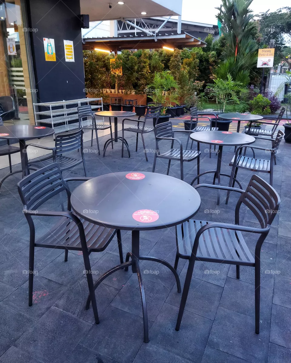 Empty black tables and chairs in a fast food restaurant