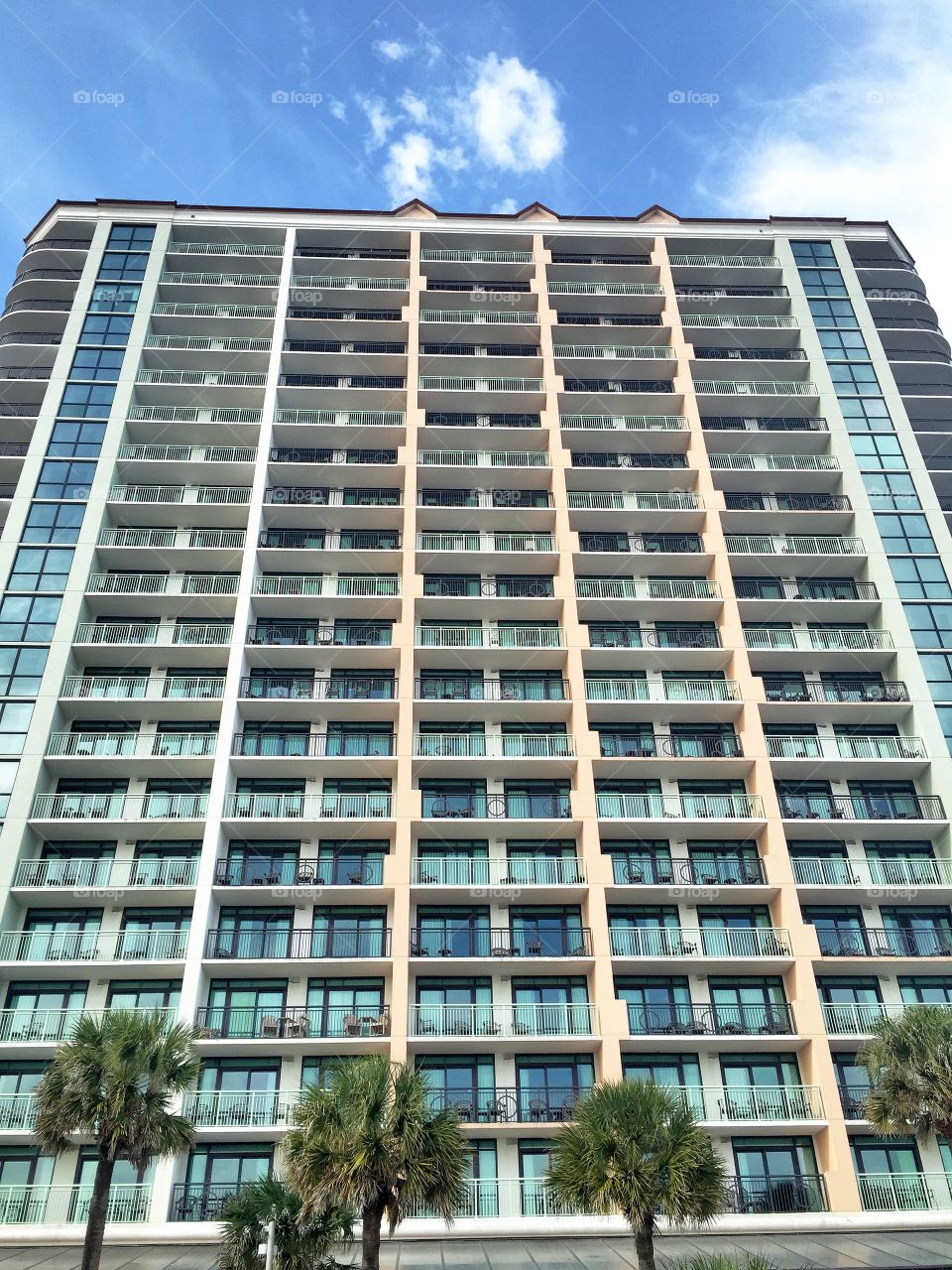 Looking up at a large condominium building.