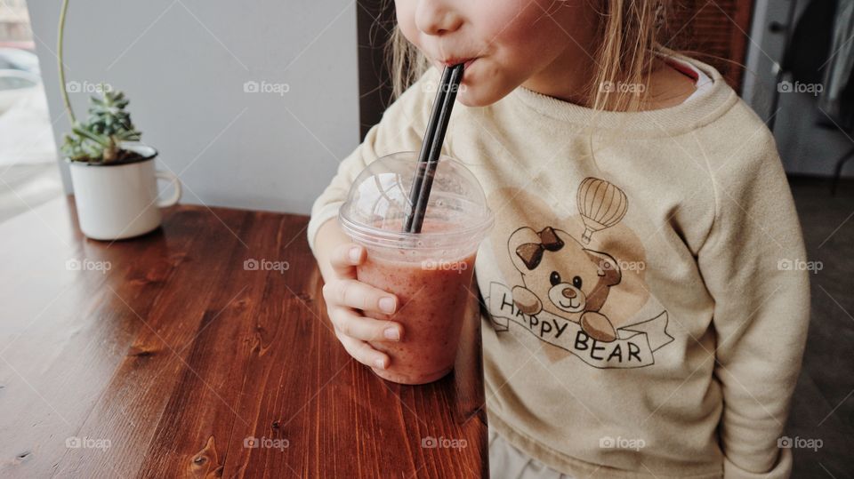 Little girl drinking smoothie 