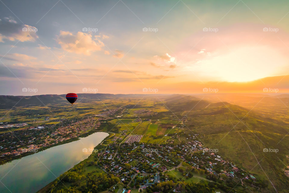 Countryside - I love the outdoors! Image of hot air balloon trip over a valley with small village and lake at sunrise