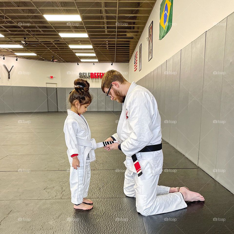 Little girl gets Jiu Jitsu stripe on her belt, ready for the next phase, excelling in Jiu Jitsu, making strides in MMA 