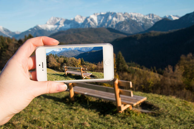 Person hand photographing empty bench