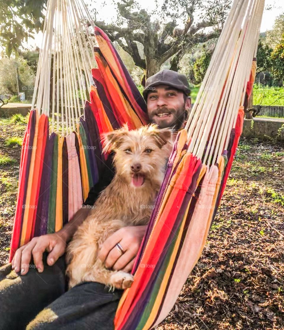 A man and his dog, just chilling in a hammock