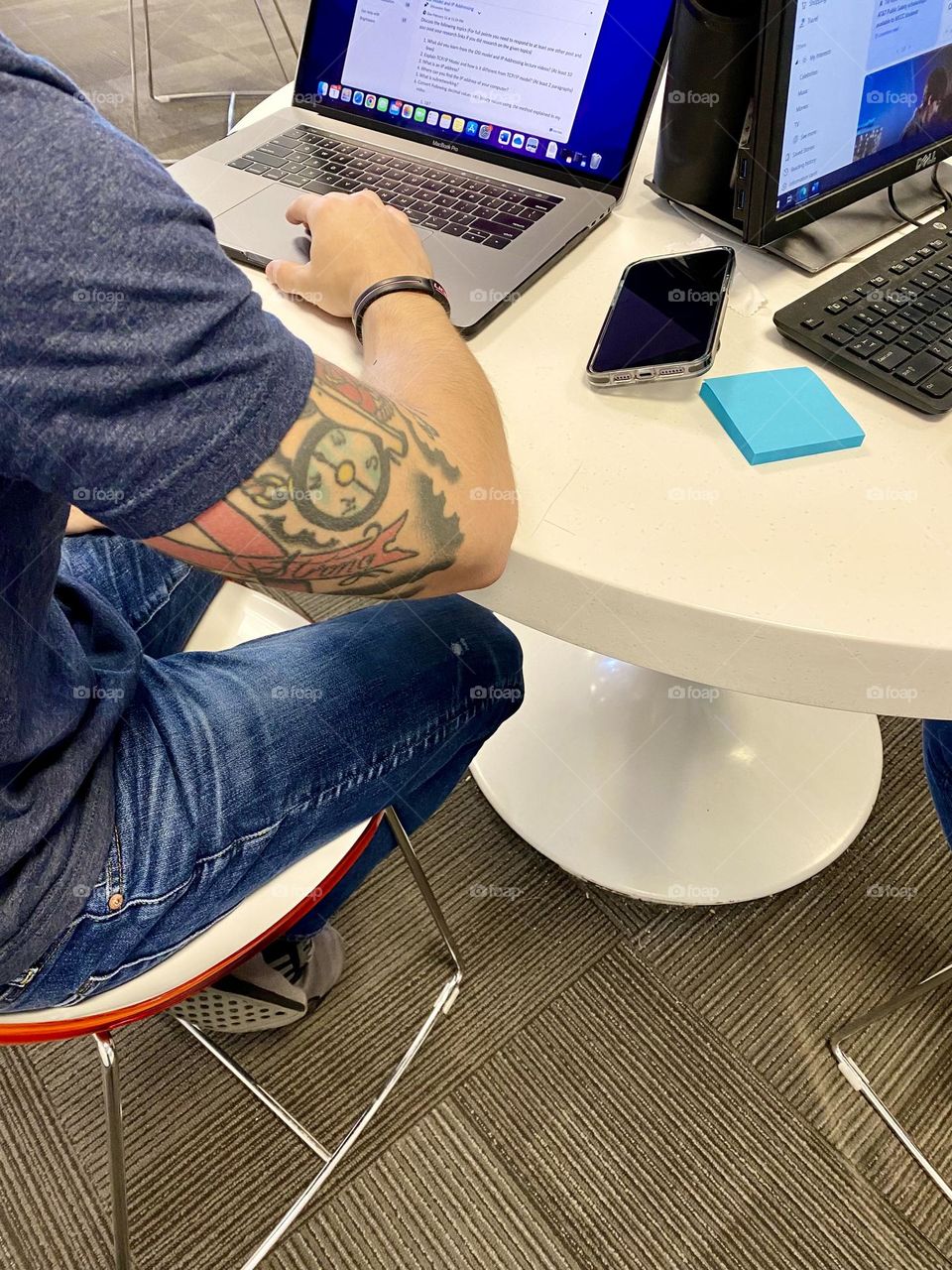 Man working on a computer, tattoo on his arm