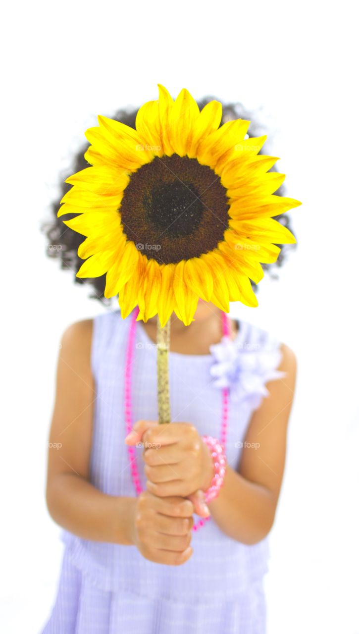 Flower Child Eclipse . A sunflower eclipses a young girls face. 