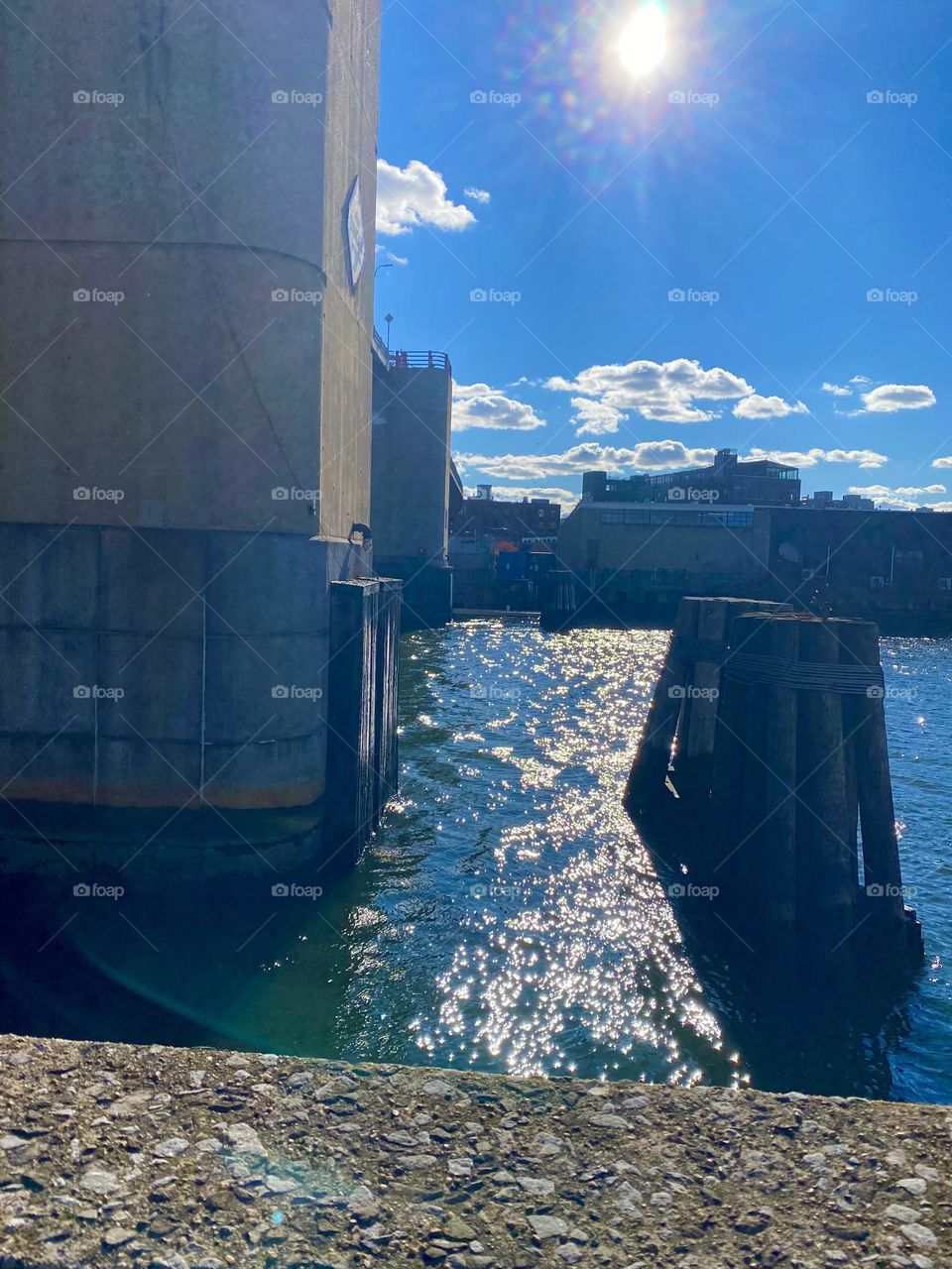 A view across the East River to the Greenpoint, Brooklyn side at Newtown Creek in Long Island City, Queens, New York on a bright sunny afternoon in October 2021. The wood pilings can be seen at 25 ft from the Pulaski Bridge. Hypnotic Productions
