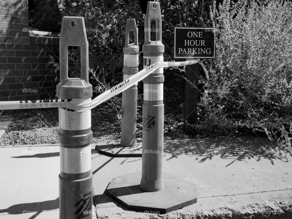 Pylons and tape keep people from walking on a newly pored sidewalk. 