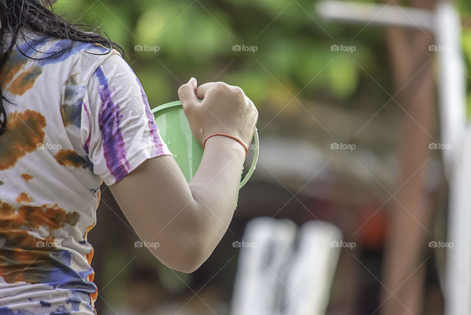 Hand holding Plastic bucket play Songkran festival or Thai new year in Thailand.