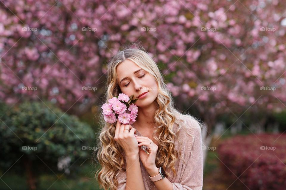 Young woman and blooming Sakura 