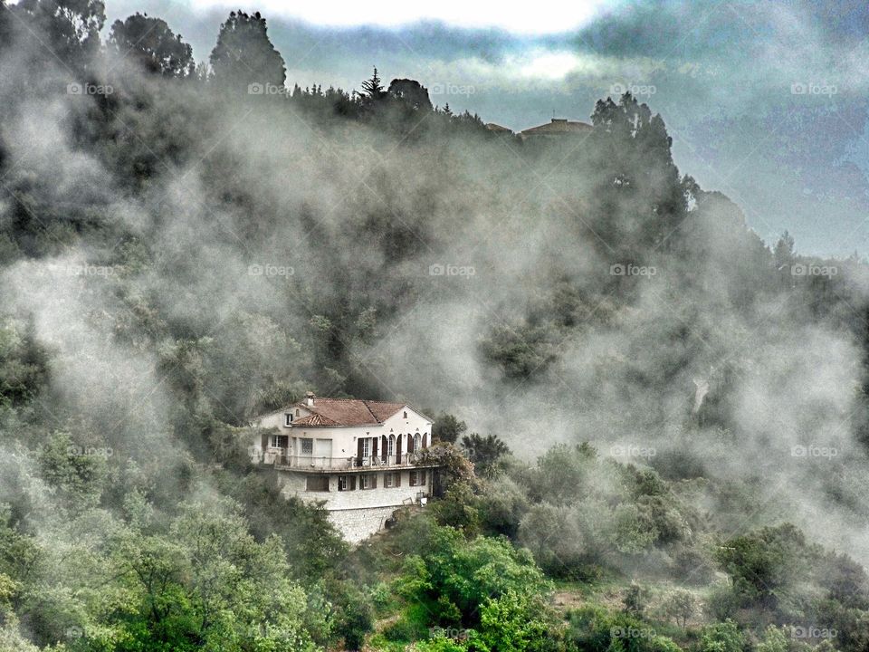 Morning fog lifting and revealing beautiful mountain retreat in Eze - France