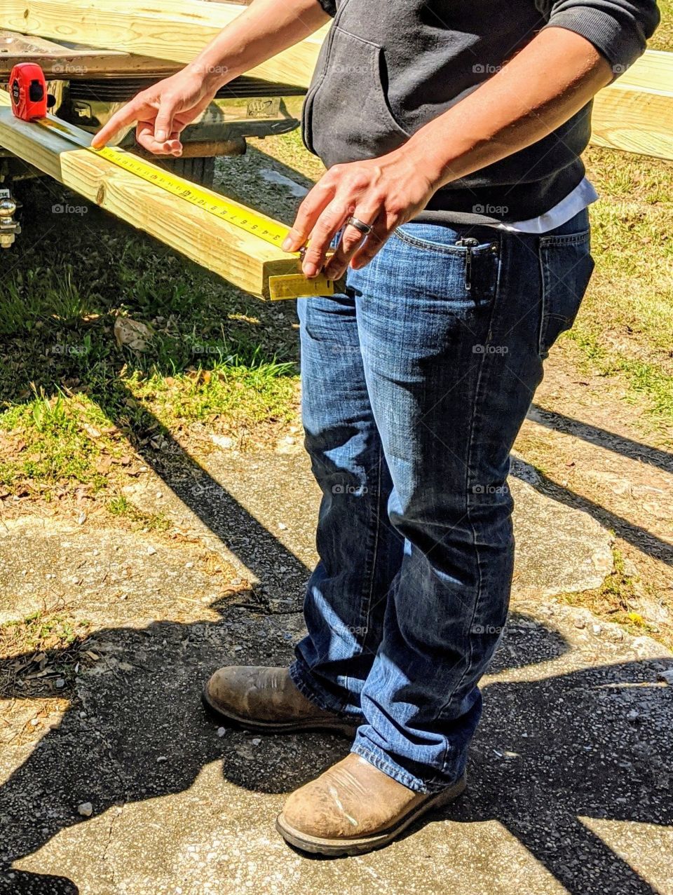 Man measuring lumber to build with hands