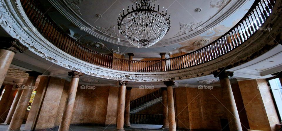 Lounge of an abandoned Soviet sanotarium with crystal chandelier, staircases, pillars and railings in Tskaltubo, Georgia.