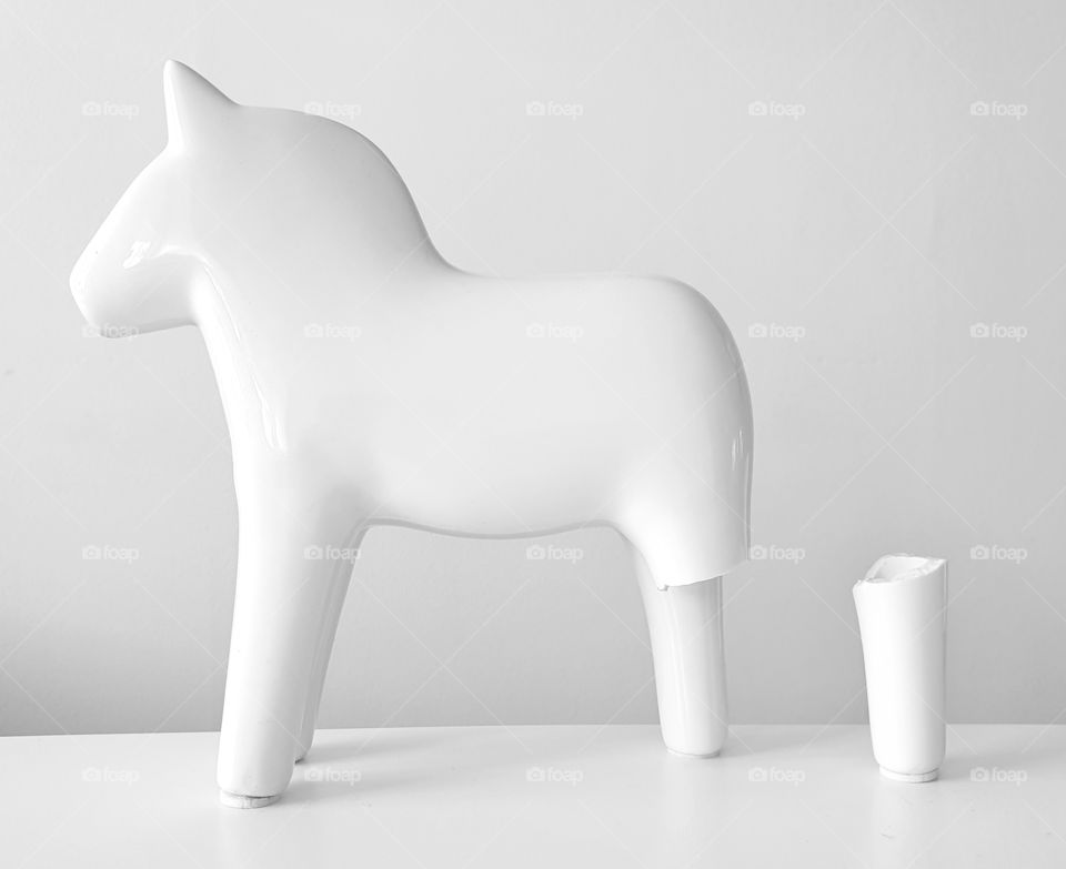 All-white porcelain Dala horse with broken leg (view from left side)