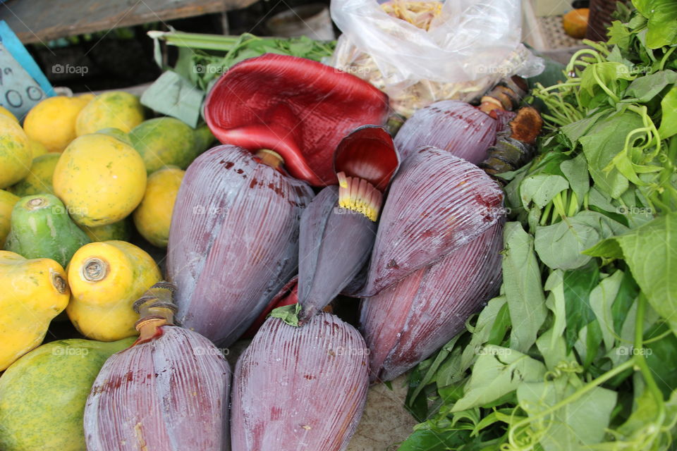 Banana flowers and fruit on market stall