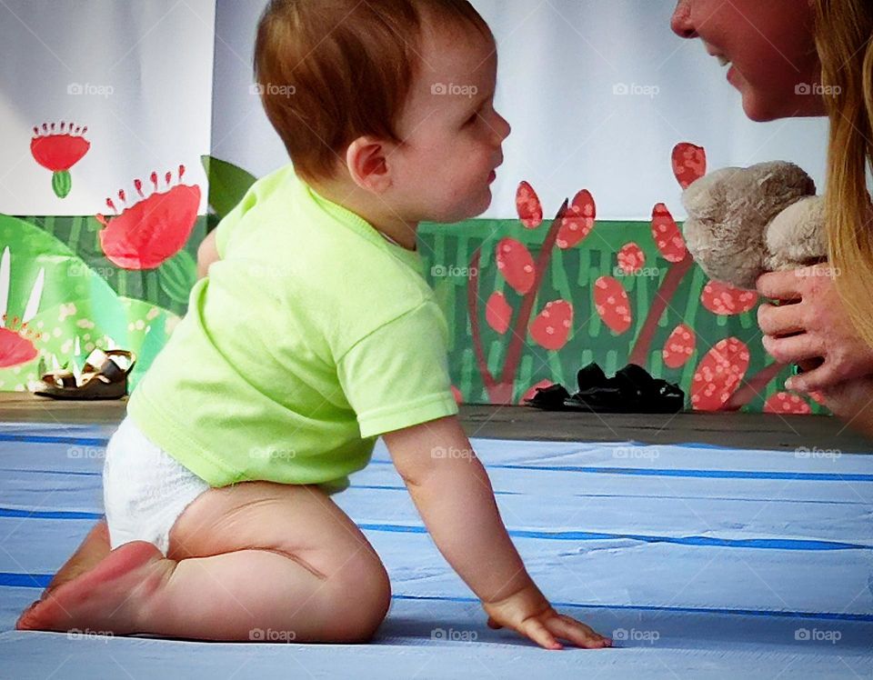 Happiness.  A smiling little boy in a diaper and a smiling mother sit opposite each other on the podium.  The happiness of motherhood Photo from which the beholder has a smile on his face and happy emotions