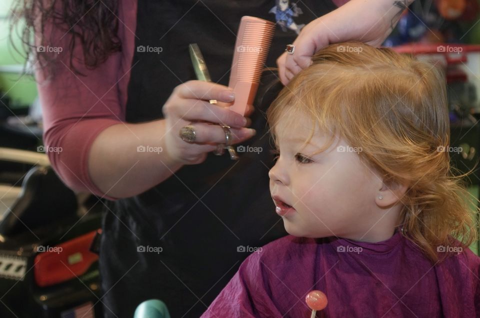 Mother is combing her daughter's hair