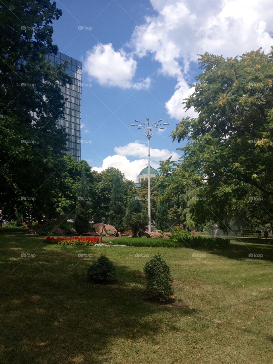 Lawn with flowerbed, trees and a lantern in a park