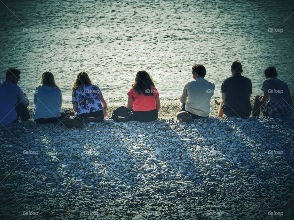 Beach . Row of people enjoying summer sunshine