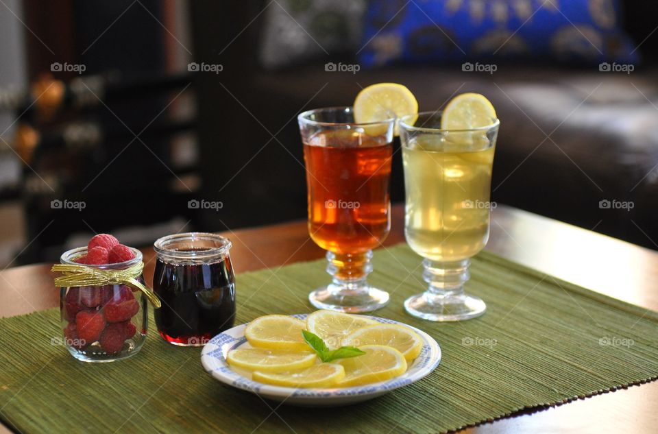 Raspberry and lemon juice in glasses served with honey