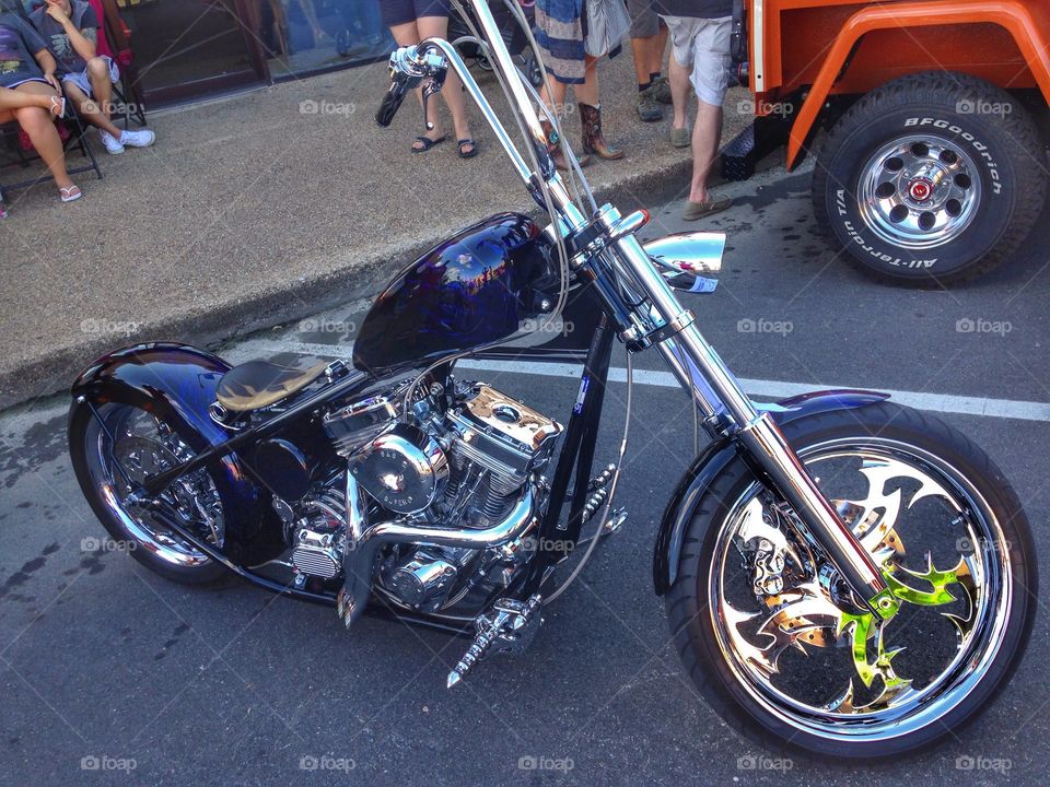 Fast ride. Chopper bike at a car show