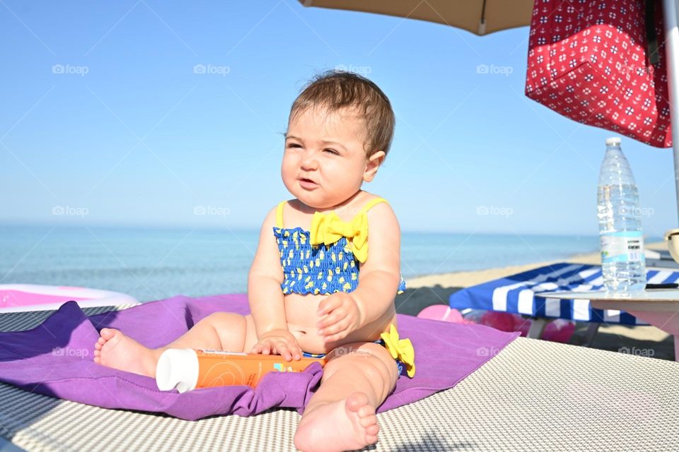 little girl on sunbed on the beach
