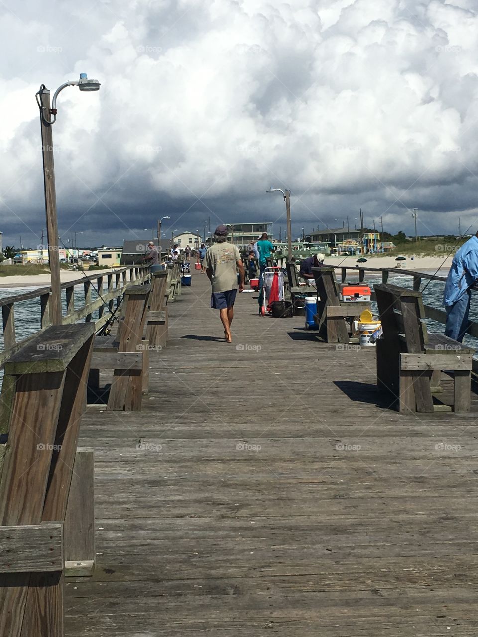 This older man walking down the pier seemed very much at home there: walking barefoot, pausing to talk to people, and then picking up his own line to fish. 