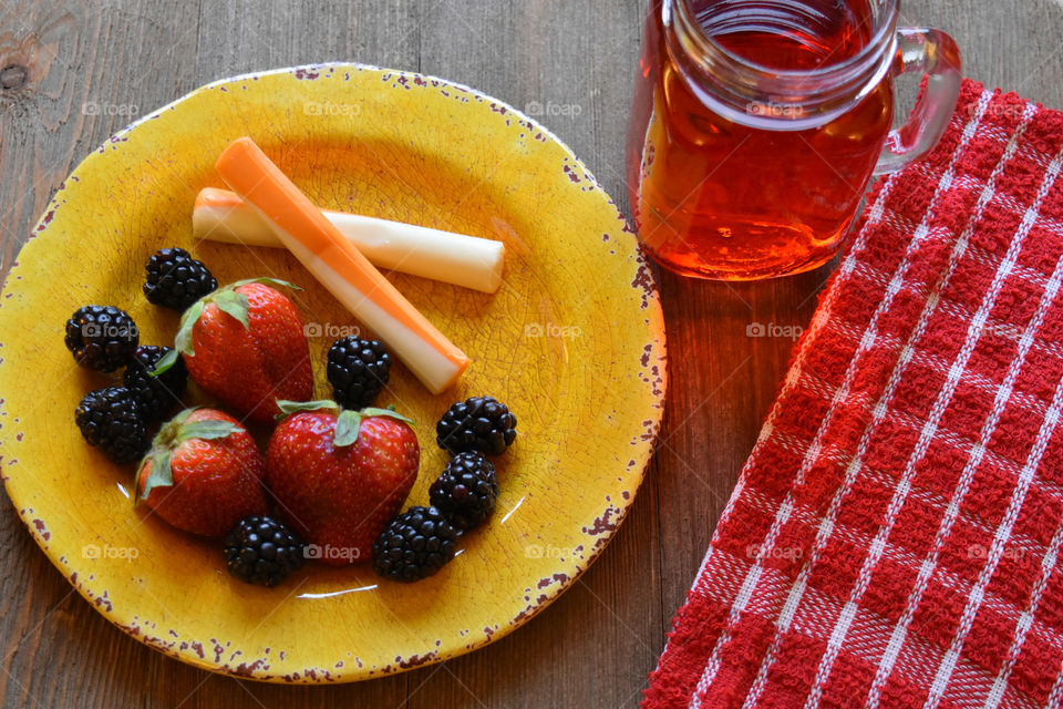 Cheese sticks and fruit with a glass of juice