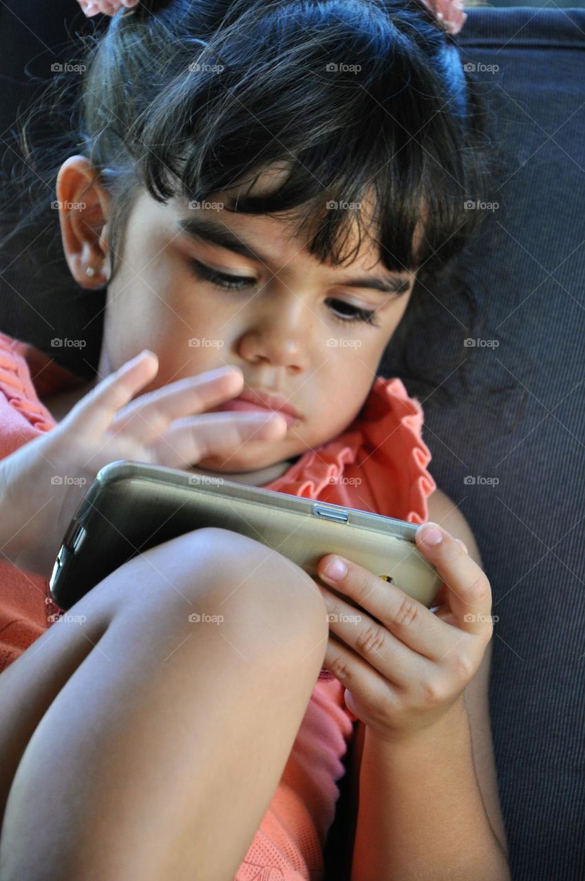 Aproveitando a distração da mamãe, menina ao celular