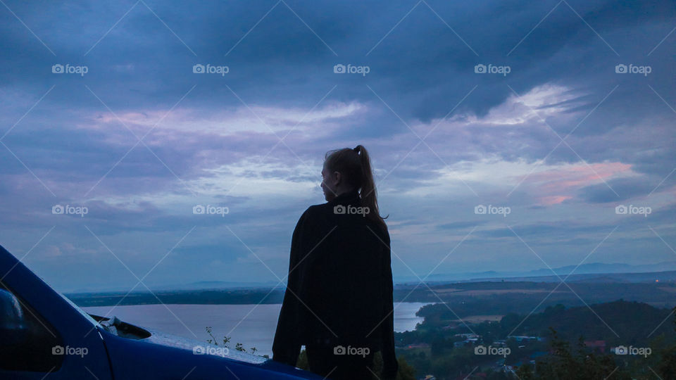Outlook from hill on water reservoir, during dark day with overcast sky