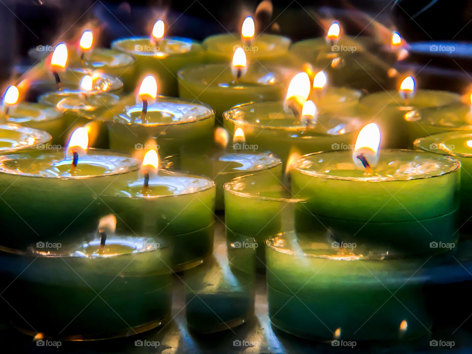 Lit green tea lights viewed through a kaleidoscope lens