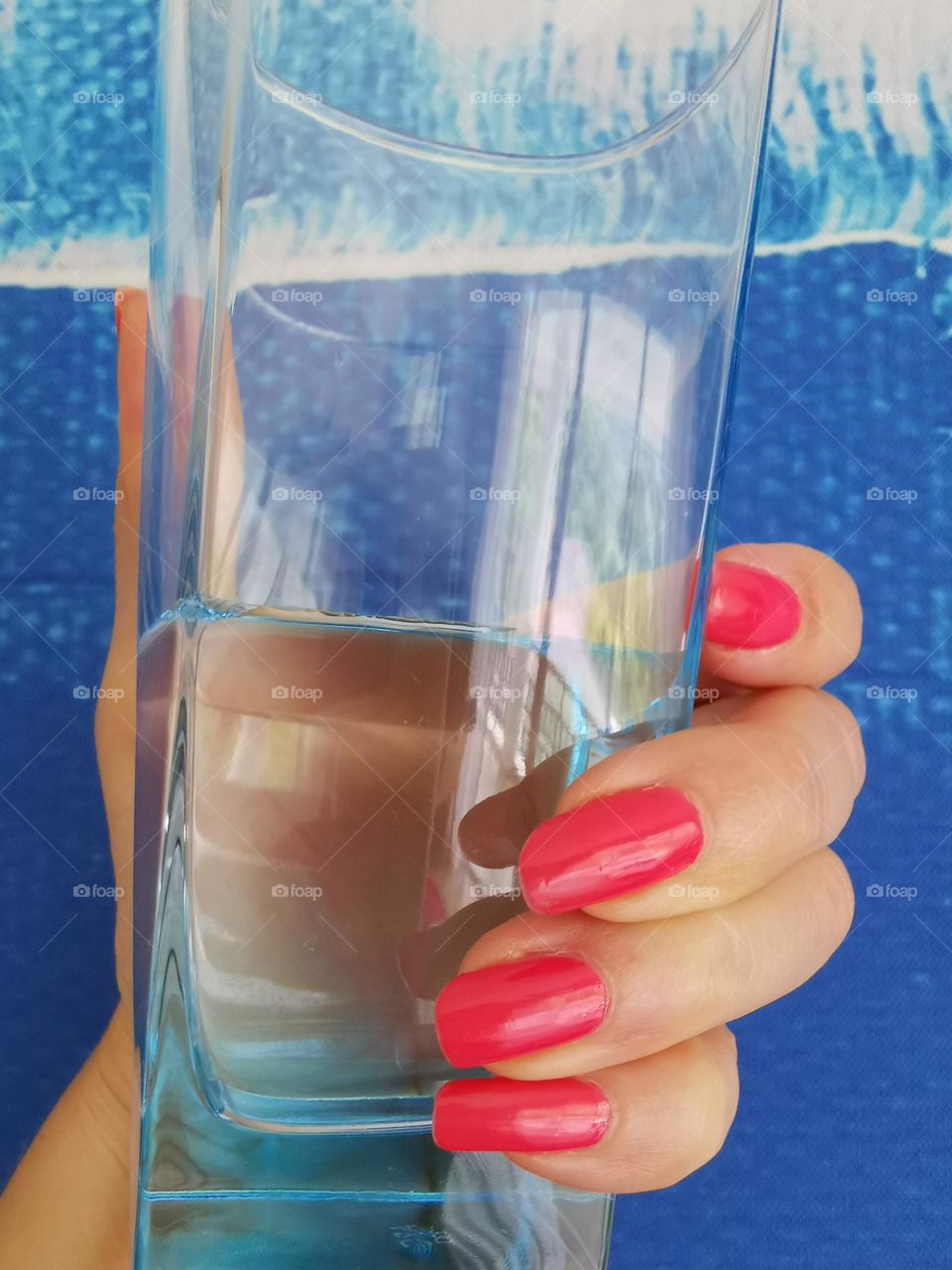 Pink color manicure. My natural nails. Glass of water.